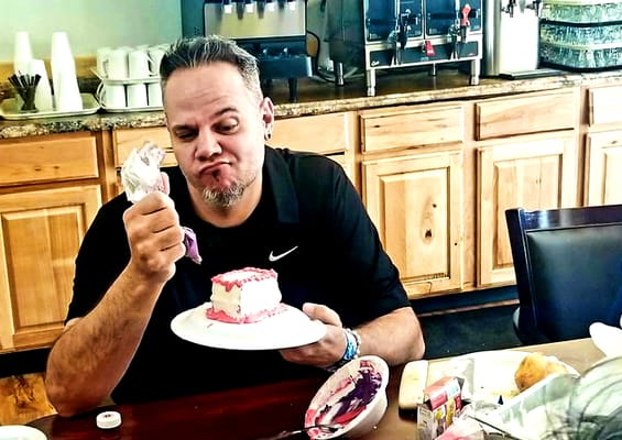 A man enjoying cake in a dining area