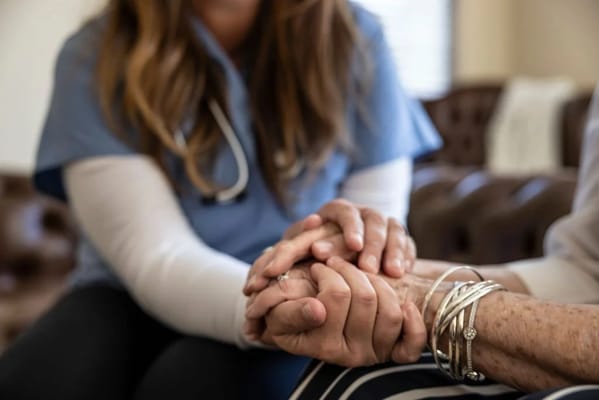 Caregiver holding hands with a senior resident
