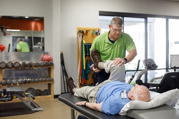 A staff member assisting a resident with therapy
