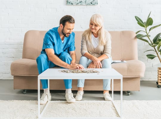 Staff helping a resident with a puzzle in a cozy lounge