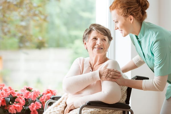 Caregiver assisting a senior resident with a smile