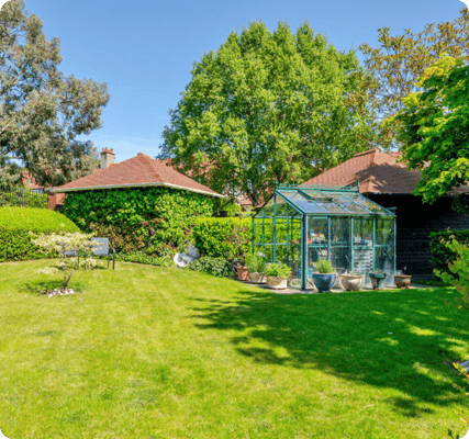 Beautiful garden area with greenhouse and well-maintained lawn