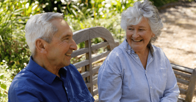 Two smiling residents enjoying a moment together outdoors