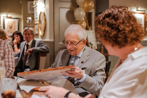 Resident joyfully unwrapping a gift at a celebration