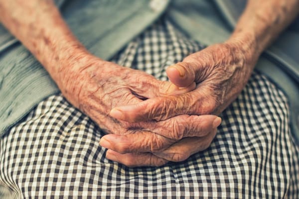 Elderly hands resting on a lap