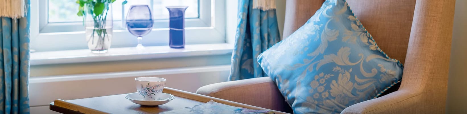 Comfortable chair by a window with decorative pillow