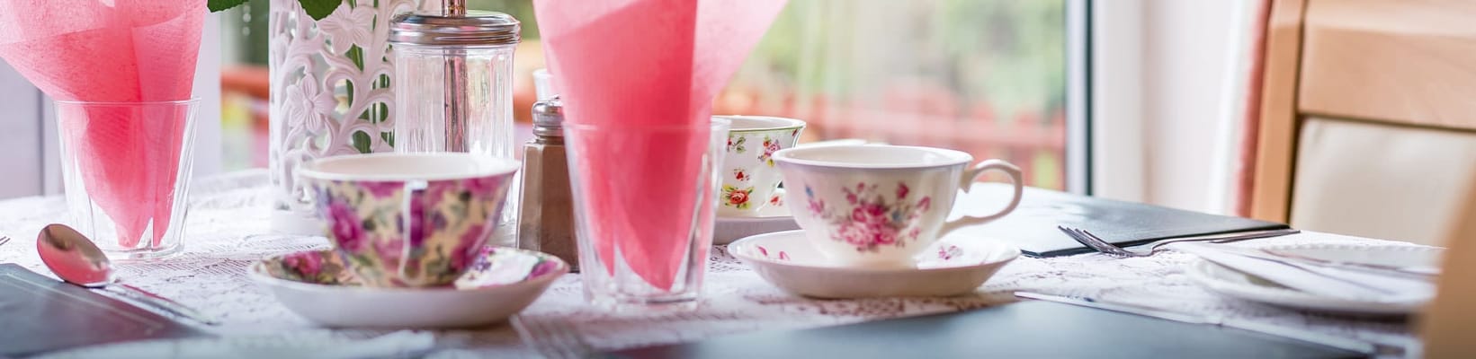 A beautifully arranged dining table with floral cups