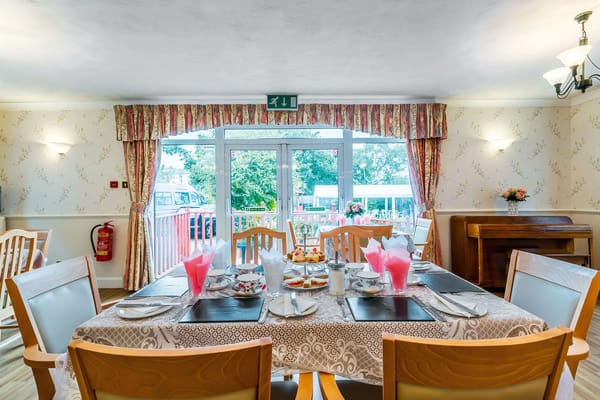 Well-set dining table with floral décor in a bright dining room