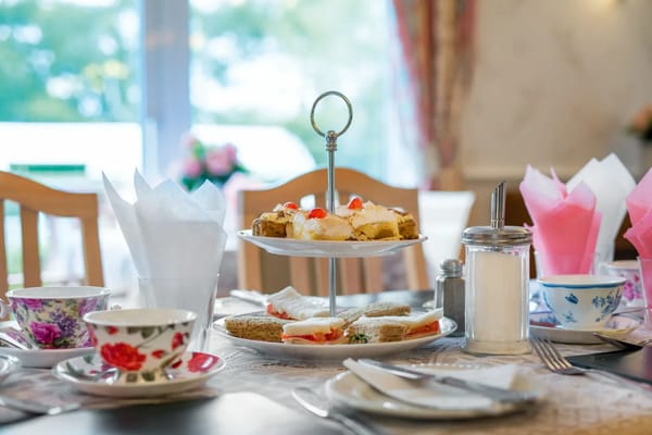Elegant table setting with afternoon tea and snacks