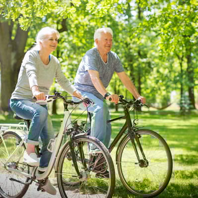 Older adults biking together in a park