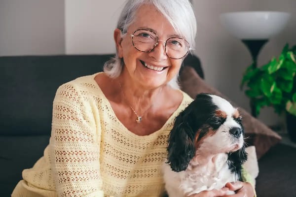 Senior woman smiling with a dog on her lap