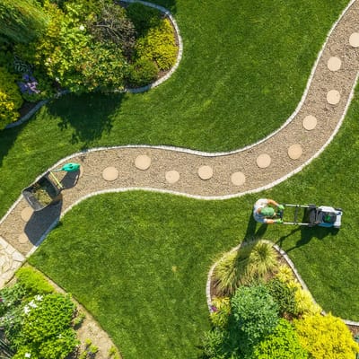 Aerial view of a garden with a person mowing grass