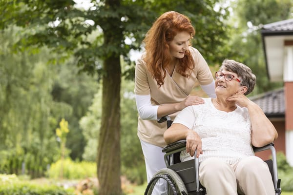 Caregiver assisting a resident in a garden setting