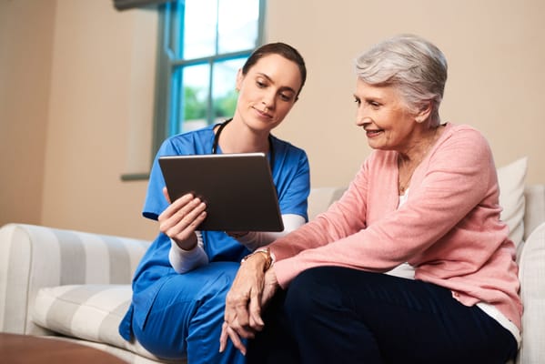 Staff member showing tablet to senior resident