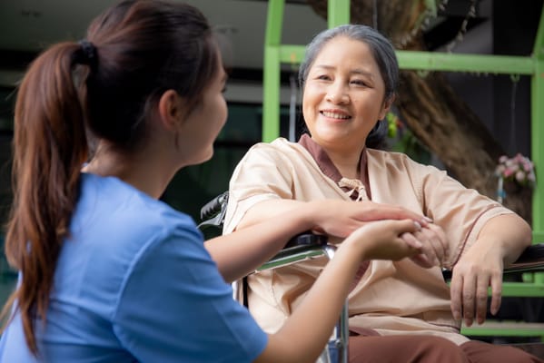Caregiver holding hands with a resident outdoors