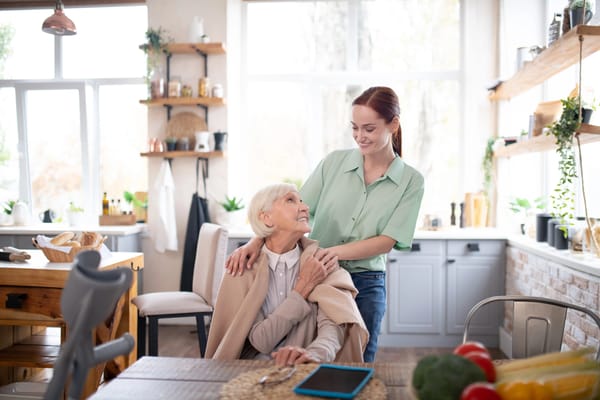 Caregiver and senior sharing a moment in a cozy kitchen