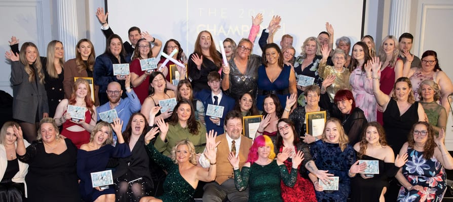 Group of staff celebrating with awards at an event
