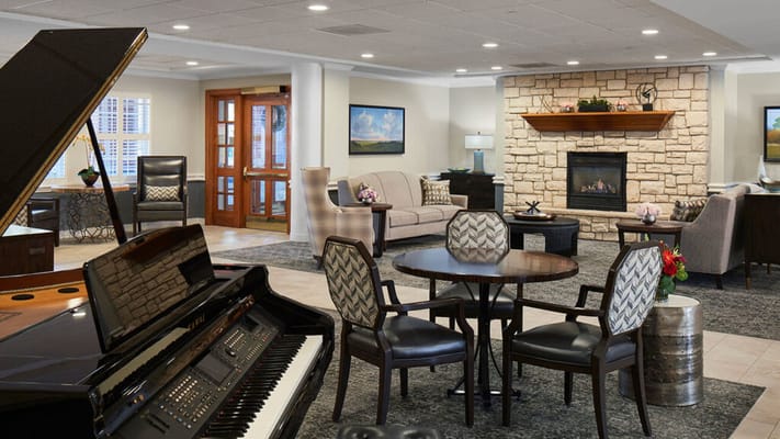 A cozy common area with seating and a piano