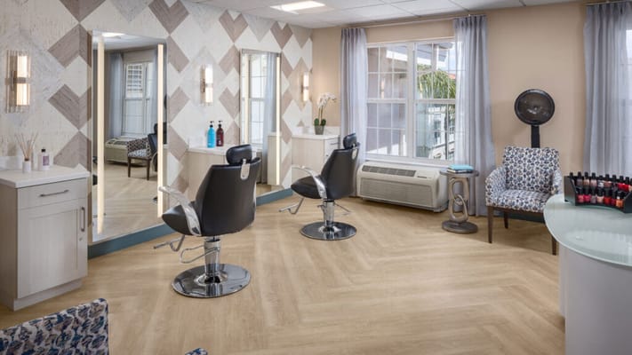 A bright salon area with styled chairs and natural light