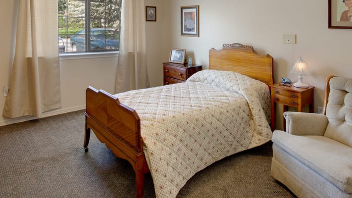 Cozy resident room with a bed and armchair