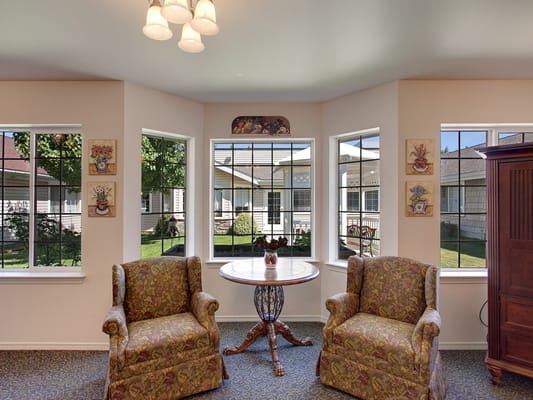 A bright seating area with two chairs and windows