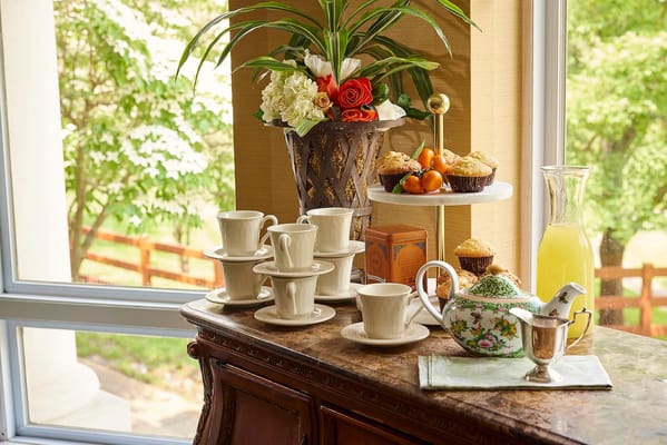 Tea and snacks arranged near a window with plants