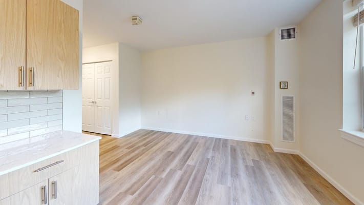 A bright, empty interior room with wooden floors