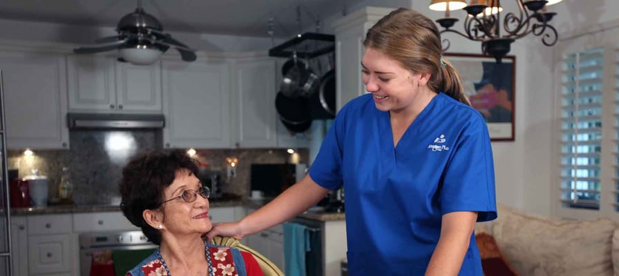 A caregiver interacting with a resident in a warm setting.