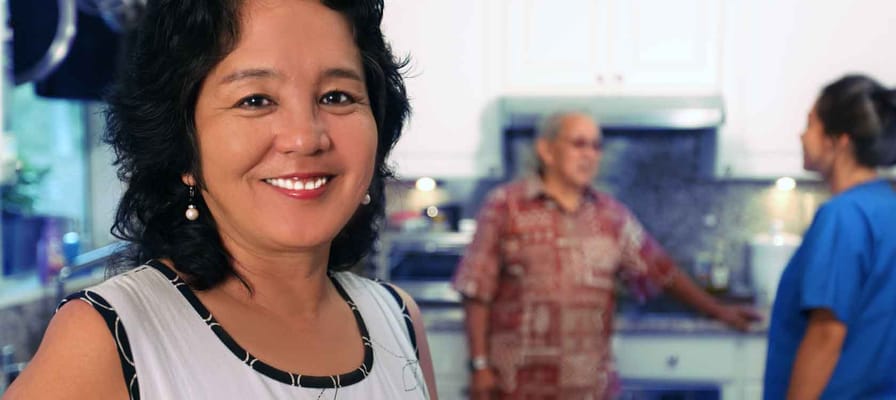 Staff member engaging with residents in a kitchen setting