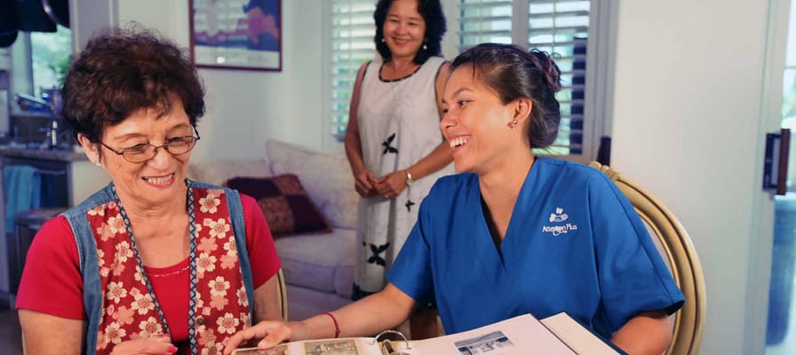 A caregiver and resident sharing memories in a cozy room