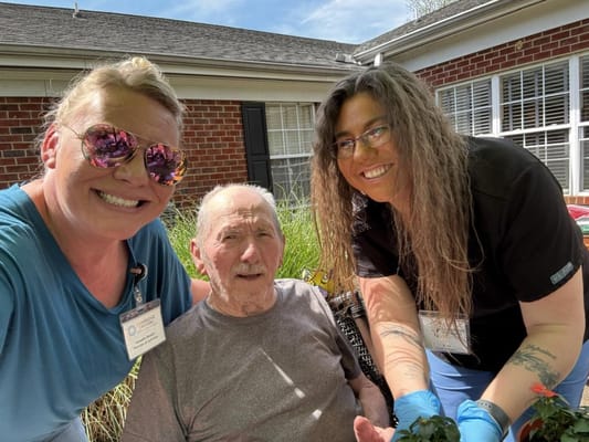 Staff and resident enjoying gardening outdoors