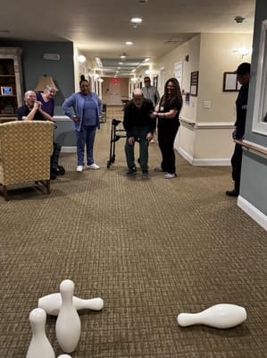 Residents and staff participating in a bowling activity