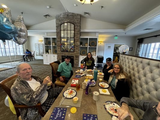 Residents enjoying a meal and celebrating in a common area