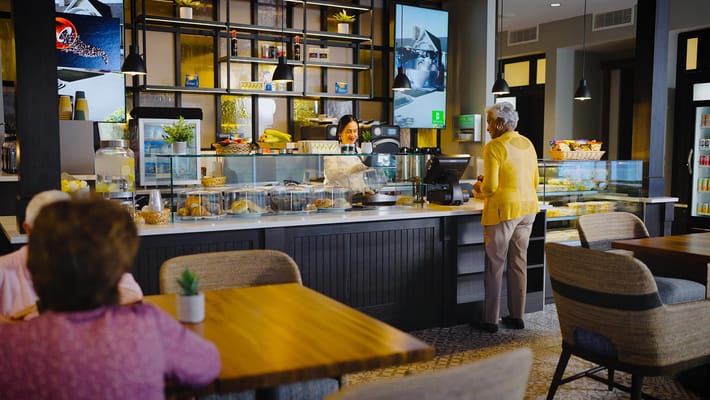 Residents interacting at a café within the facility