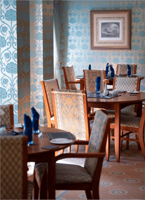 Elegant dining room setup with patterned wallpaper