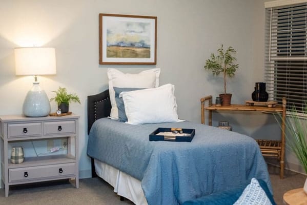 Cozy resident room with a neatly made bed and decor