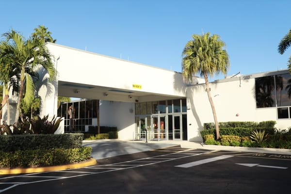 Entrance of a senior living facility with palm trees