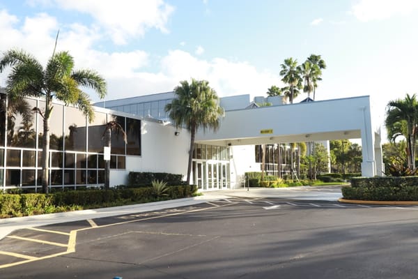 Entrance of Avalina Senior Living facility with palm trees