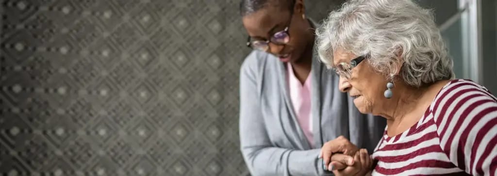 A staff member assisting a resident in an interior space.