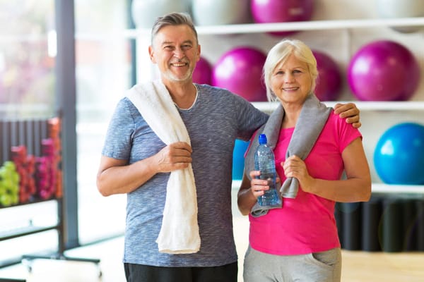 Two seniors smiling in an exercise area