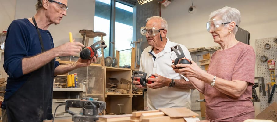 Seniors engaged in a woodworking activity in a workshop