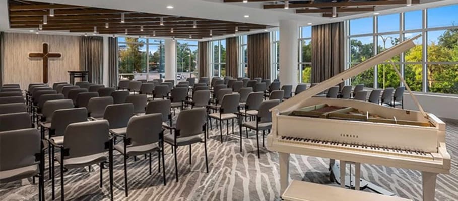 Interior view of a chapel with seating and a piano
