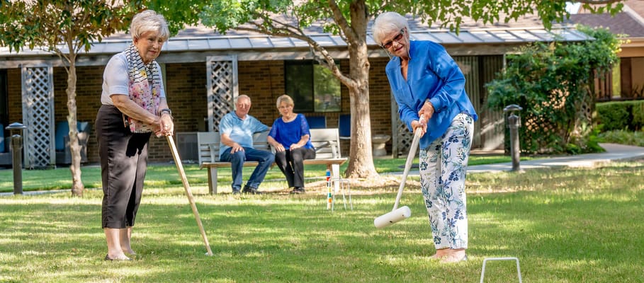 Residents enjoying a game of croquet on the lawn
