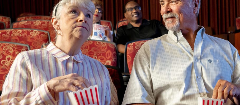 Residents enjoying a movie with popcorn in a theater