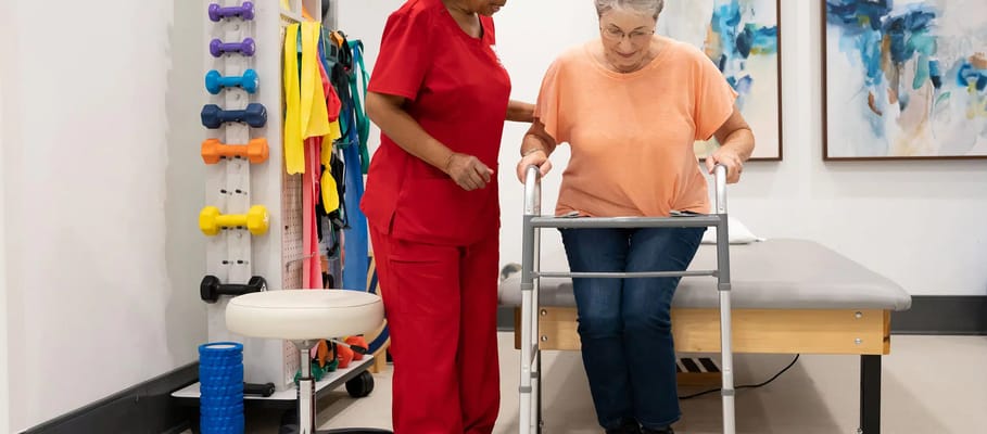 Staff assisting a resident with mobility in a wellness room