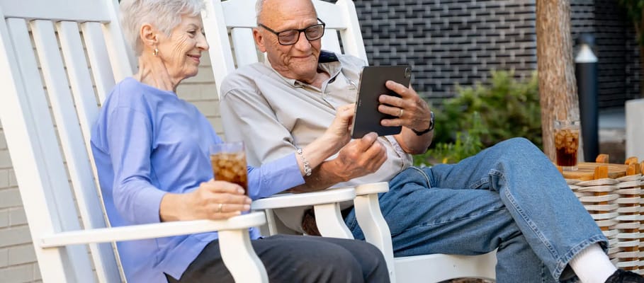 An elderly couple enjoying coffee on a patio