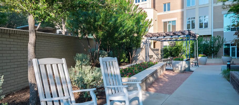 Outdoor seating area with flower beds and greenery