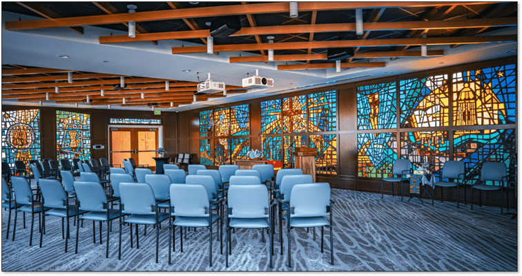 Interior view of a multipurpose room with stained glass windows