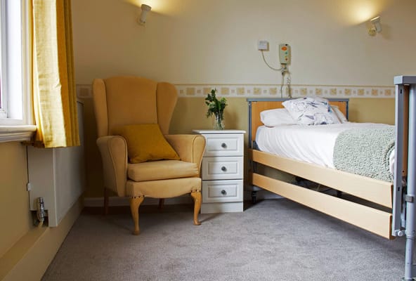 Cozy resident room with a bed and armchair