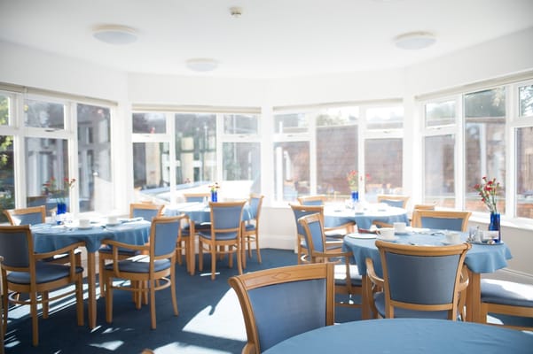 Bright dining room with blue tables and chairs.